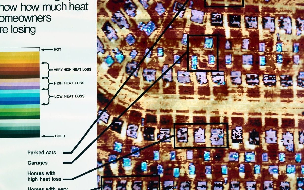 Color thermal infrared image of a house showing heat escaping through its roof and walls