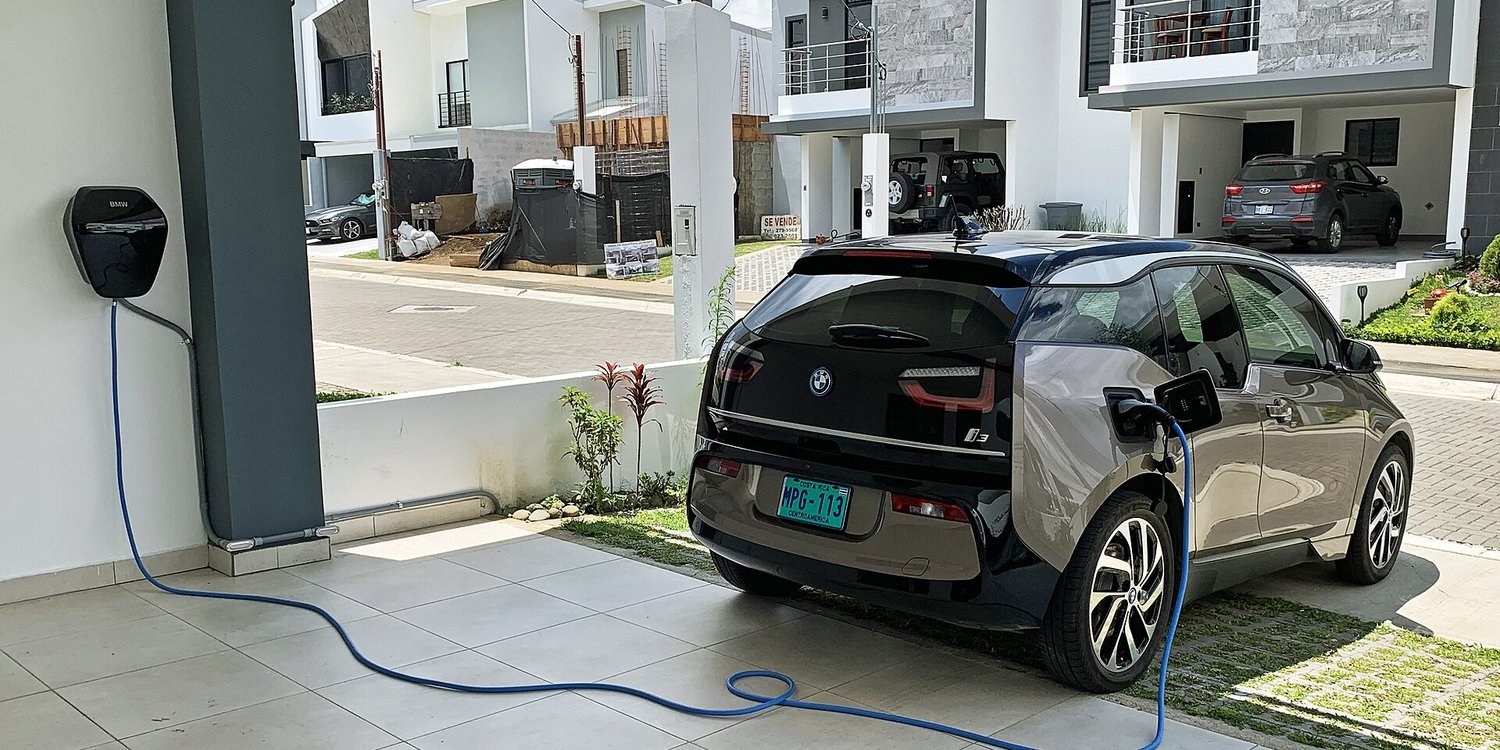 An electric car plugged into a Level 2 charger at home