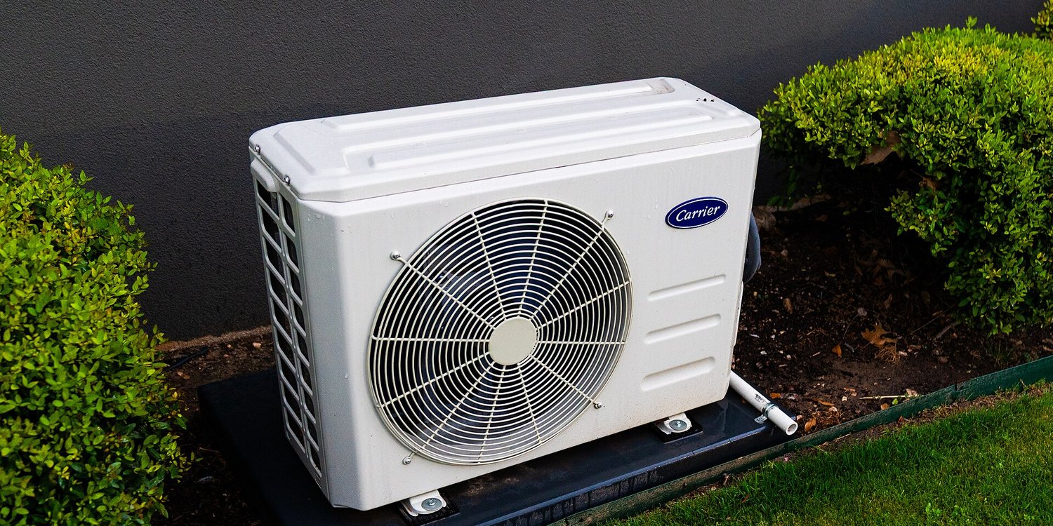 The outdoor unit of a split heat pump system beside a house